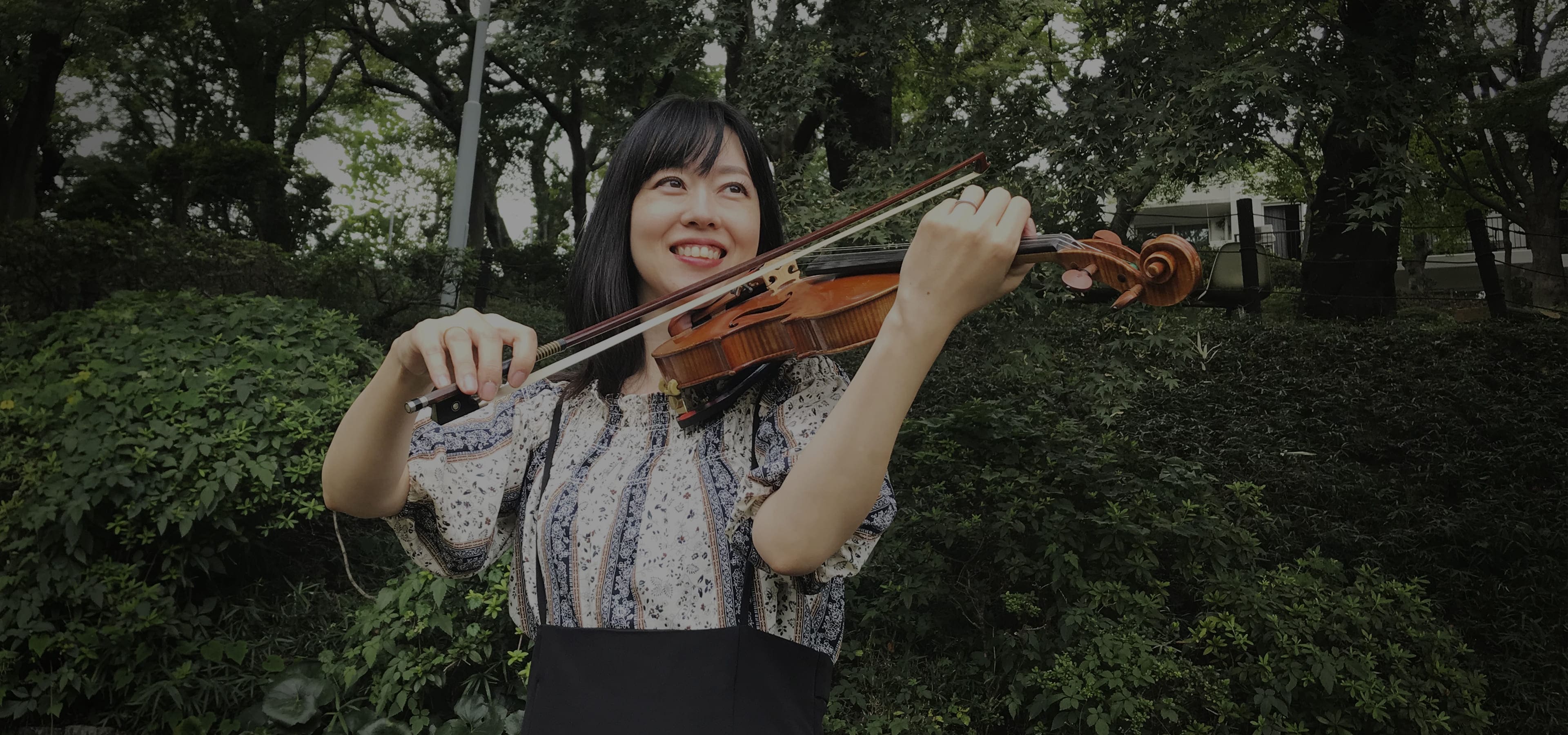 笑顔でヴァイオリンを弾く女性