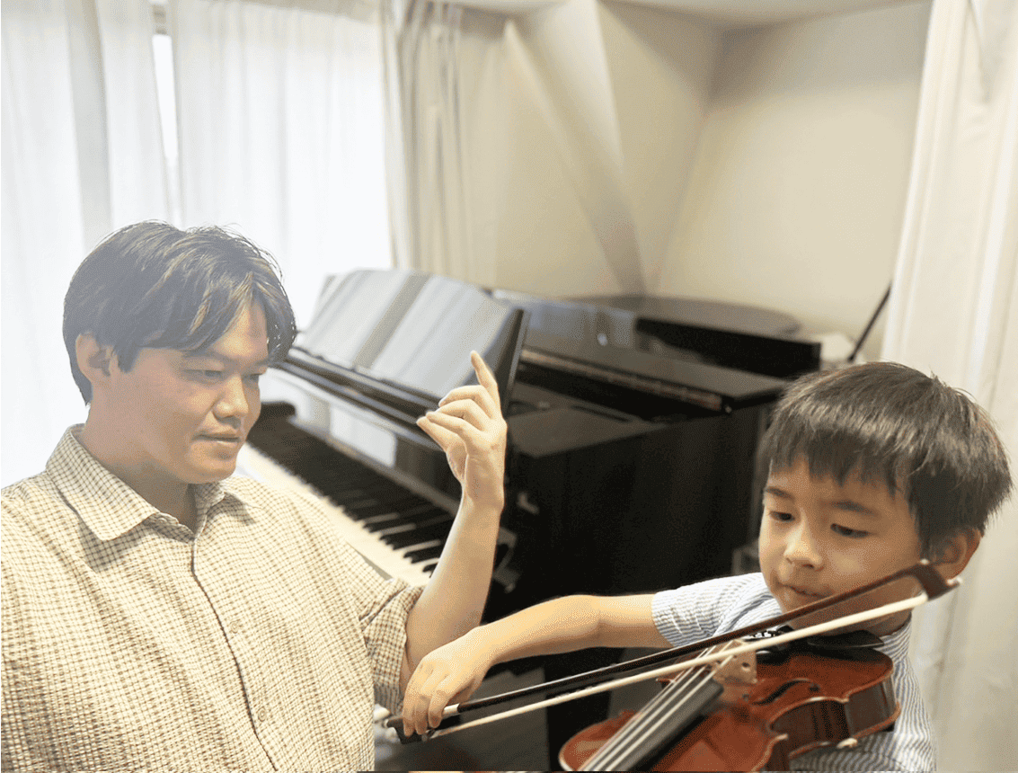 レッスン風景 講師が男子にヴァイオリンを指導している場面